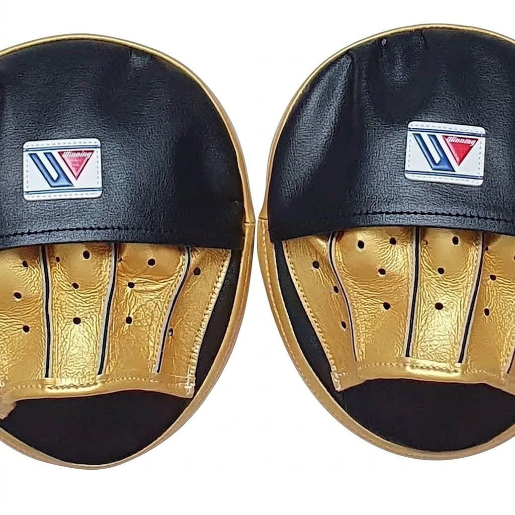 Pair of Winning black curved focus mitts with gold palm and gold rim around the striking face - palm side