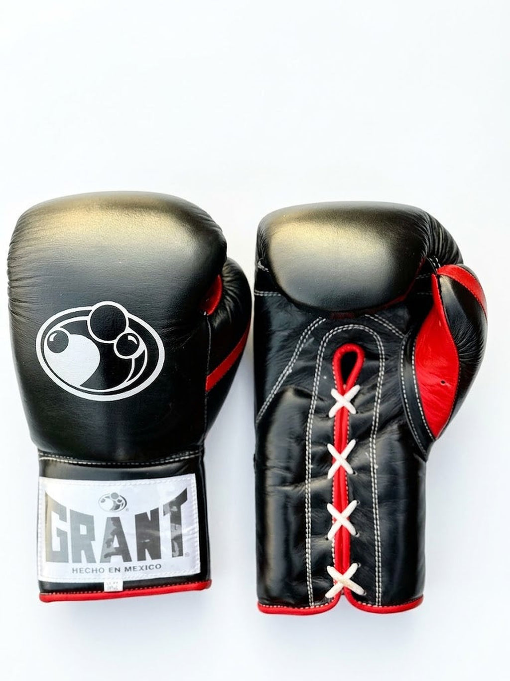 Grant all-black lace-up boxing gloves with red laces down the palm and red inner lining visible - side view