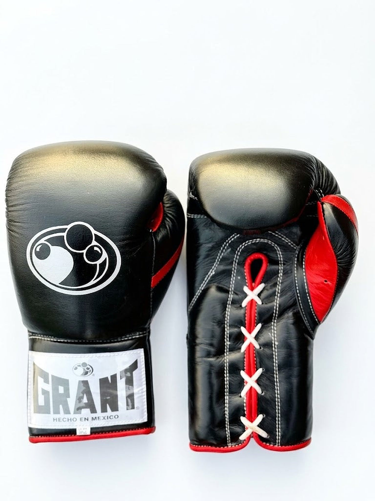 Grant all-black lace-up boxing gloves with red laces down the palm and red inner lining visible - side view