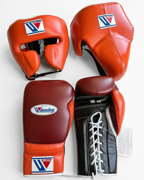 Winning orange headgear and groin guard set with maroon and black lace-up boxing gloves, W logo