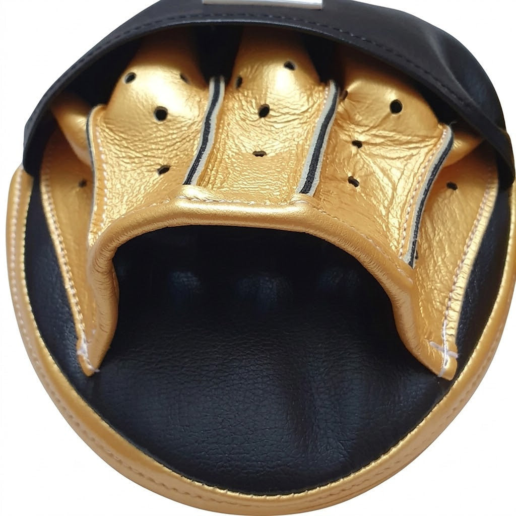 Pair of Winning black curved focus mitts with gold palm and gold rim around the striking face - close-up of the gold rim