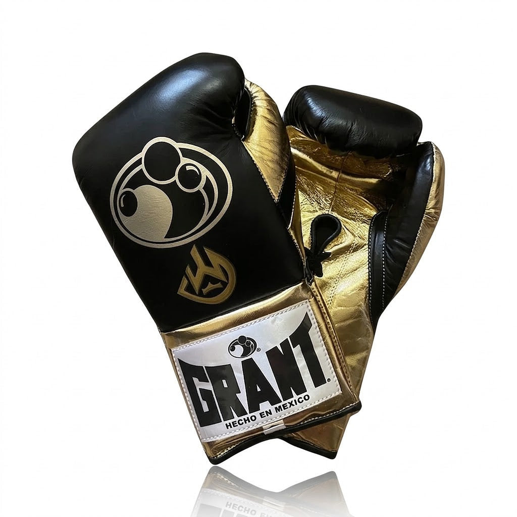 Grant black lace-up boxing gloves showing metallic gold palms, with matching black headgear and groin guard - side view