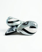 Grant boxing gloves with chrome silver back, black palm and white laces in two-tone lace-up style - side view