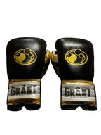 Grant black and metallic gold two-tone boxing gloves, black laces on gold palm, gold cuff patch - palm and closure detail