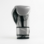 Single Cleto Reyes metallic silver boxing glove with black trim and black strap, side view