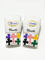 Winning white boxing gloves with multicolor cross patches on the cuff and a sample script name print