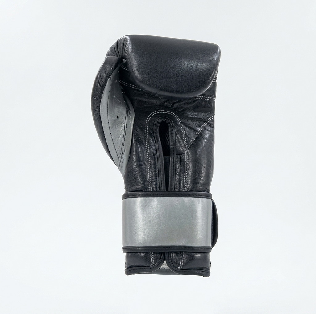 Side view of a Cleto Reyes black boxing glove showing the metallic silver cuff detail