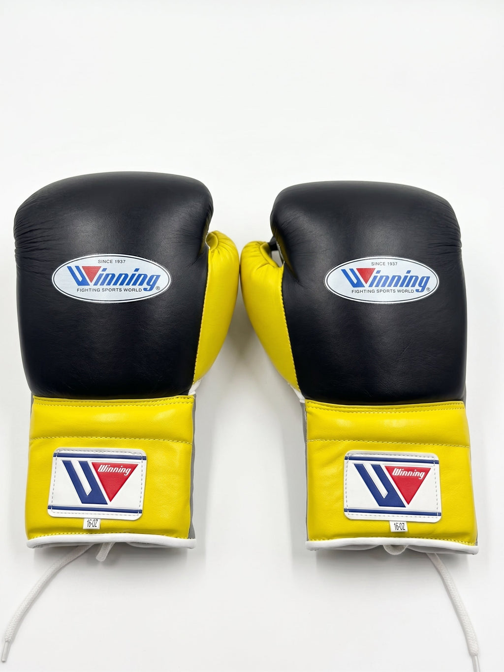 Winning black boxing gloves with gray palm and bright yellow cuff, laced up at the wrist - side view