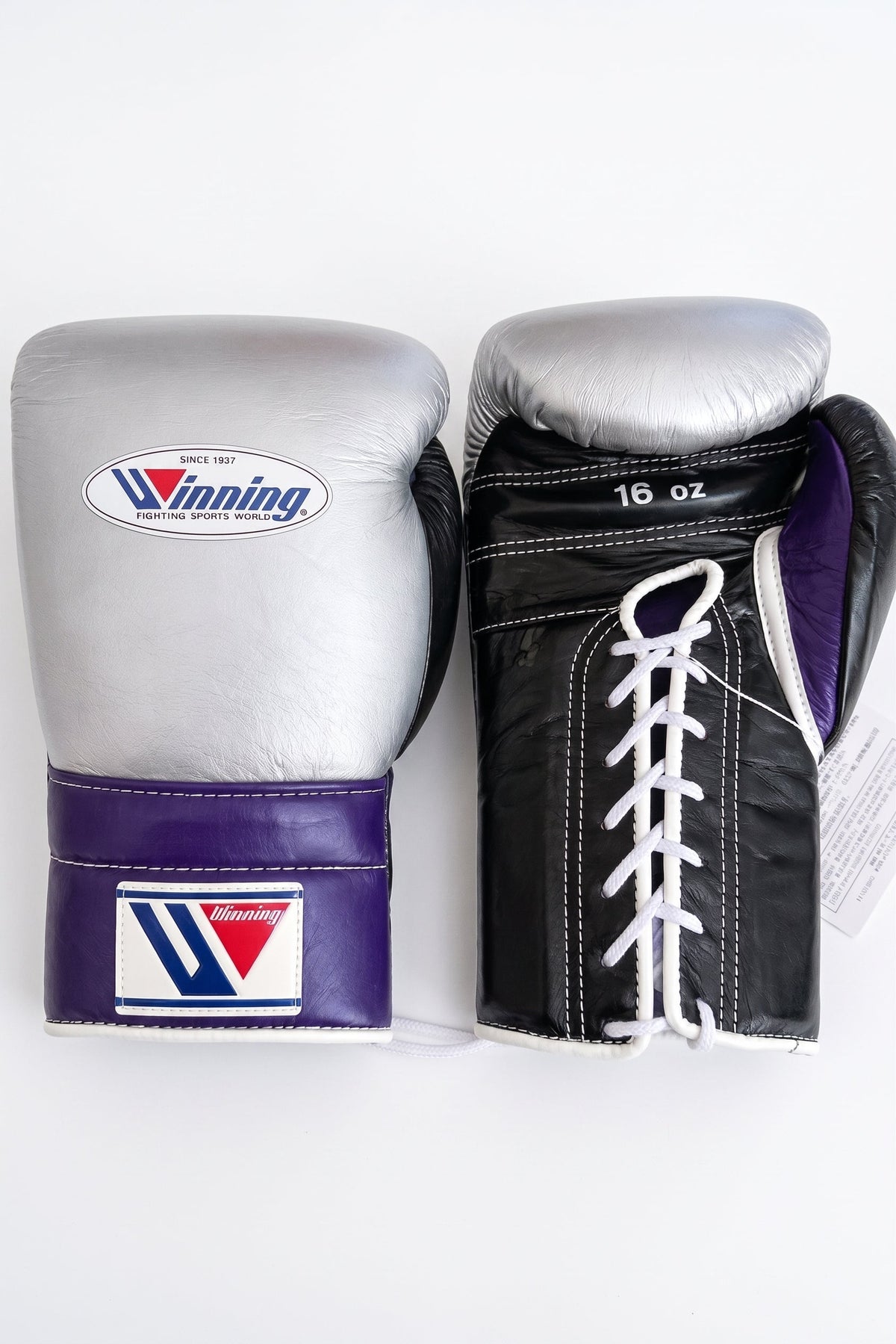 Winning lace-up boxing glove with metallic silver back, black palm and a purple cuff around the wrist