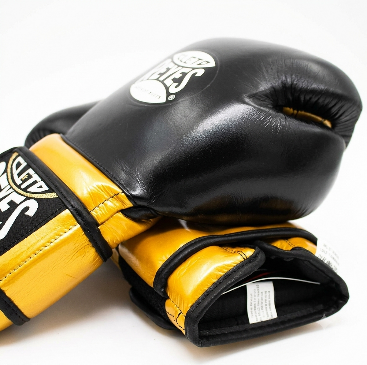 Cleto Reyes black and gold boxing gloves stacked, showing the gold wrist strap and logo