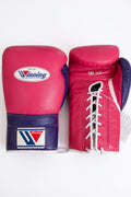 Winning lace-up boxing glove in hot pink leather with a purple cuff band, laced at the wrist