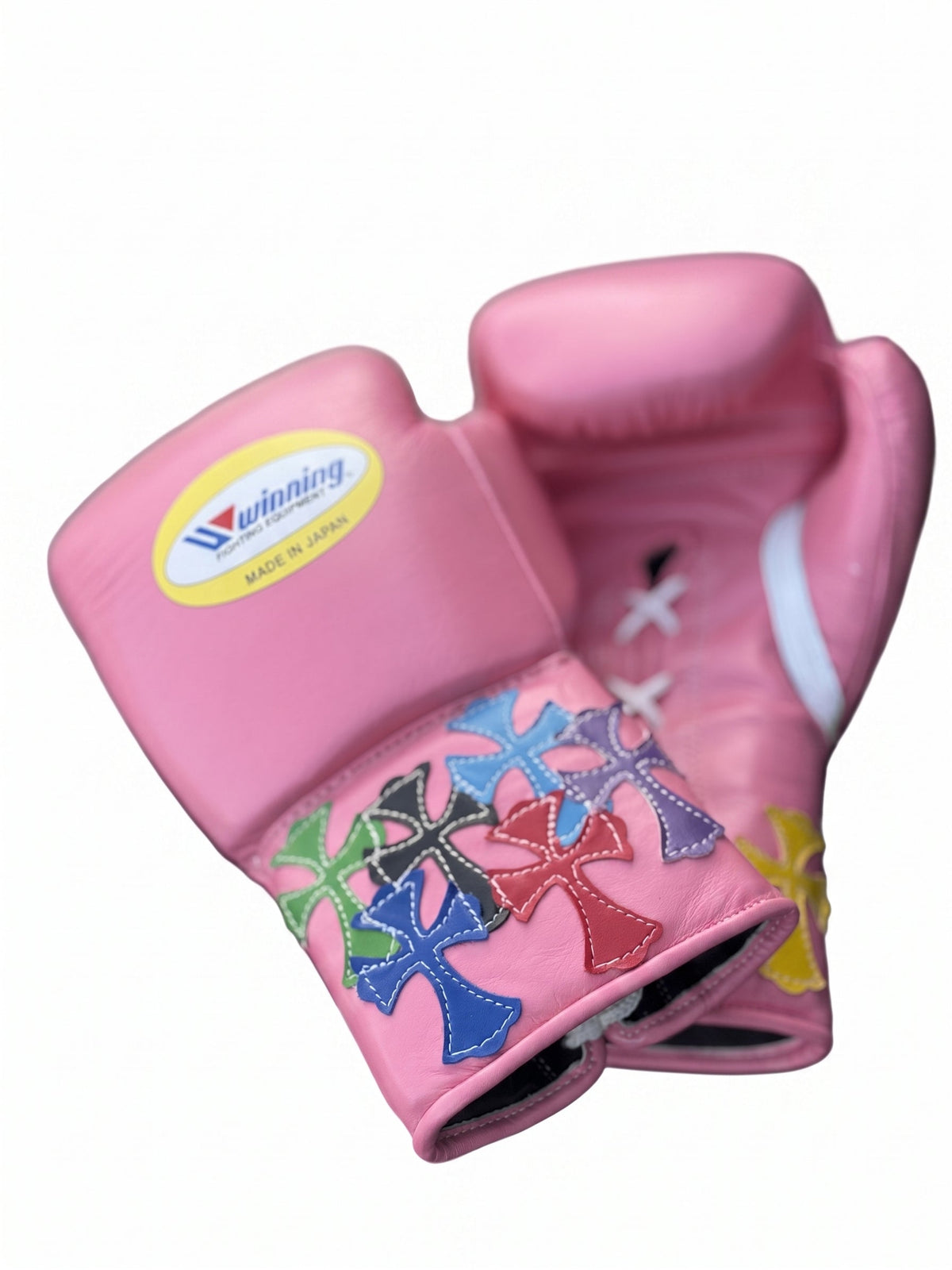 Winning pink lace-up boxing glove with multicolor cross patches around the cuff and wrist area