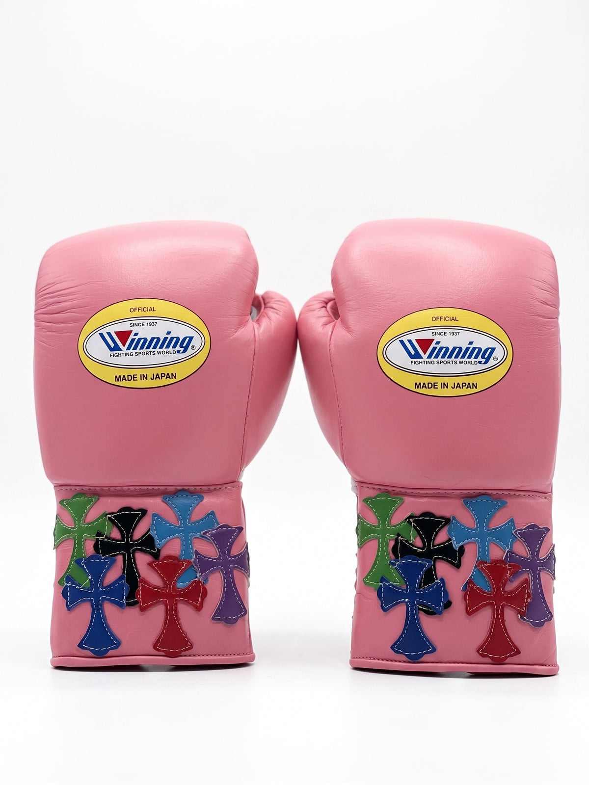 Winning pink lace-up boxing glove with multicolor cross patches around the cuff and wrist area - side view