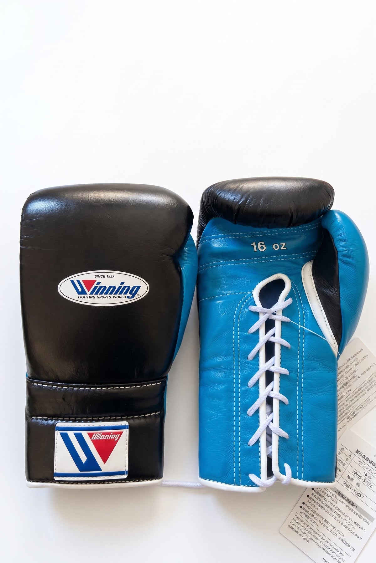 Winning lace-up boxing glove with black leather back and sky blue palm showing as the hand turns