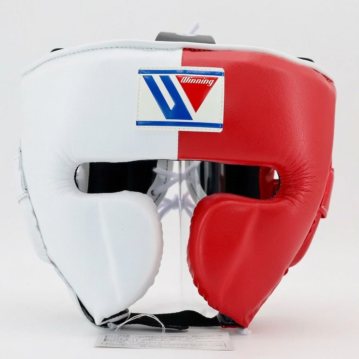 Winning headgear split into a clean white side and a red side with padded cheek protectors