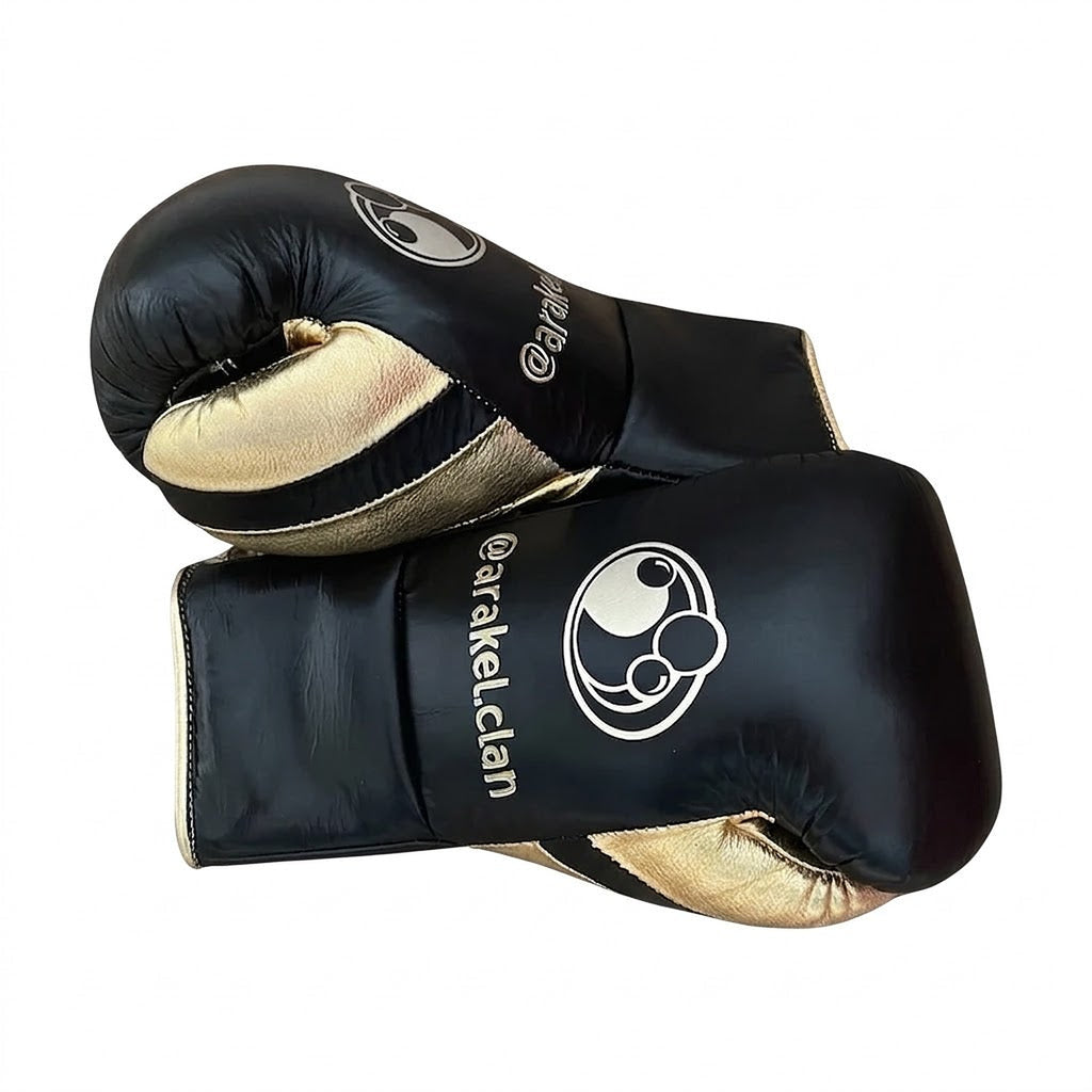 Grant black lace-up gloves with gold palms beside matching black and gold headgear and groin guard - side view
