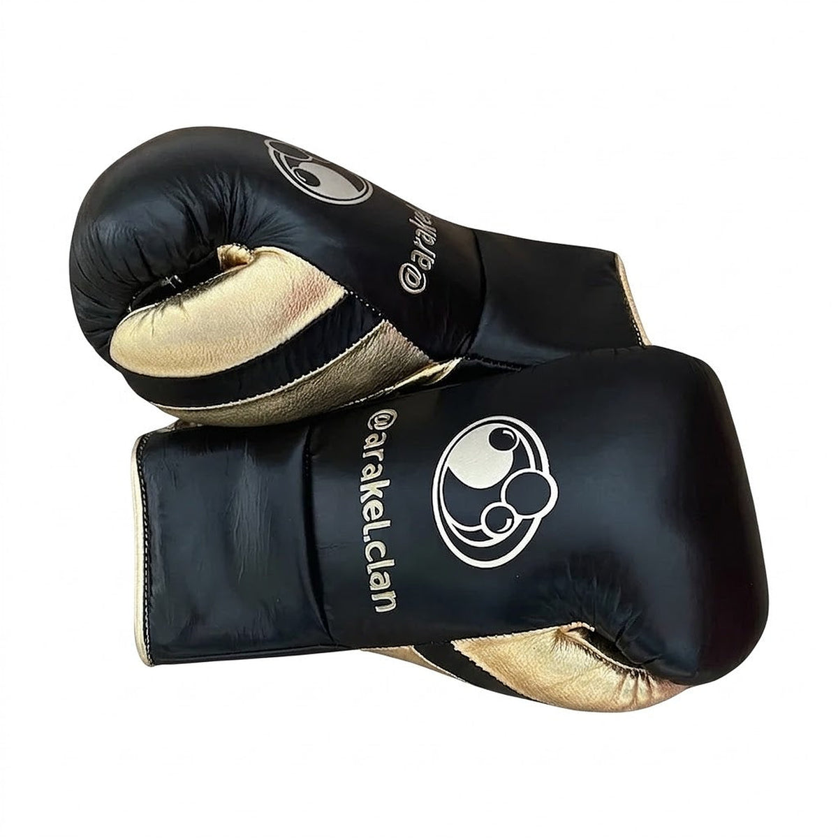 Grant black lace-up gloves with gold palms beside matching black and gold headgear and groin guard - side view