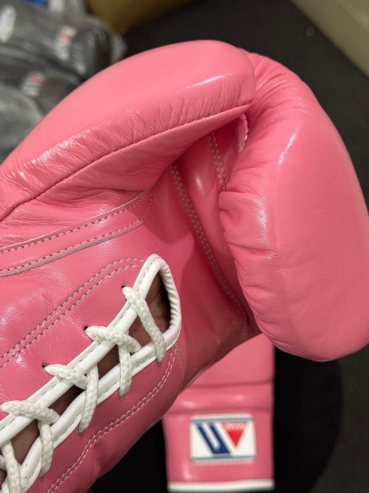 Winning MS-600 boxing gloves in full pink leather with bright white laces and the red, white and blue W logo - side view