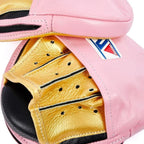Winning pink curved focus mitts with shiny metallic gold grip on the palm side, shown as a matched pair